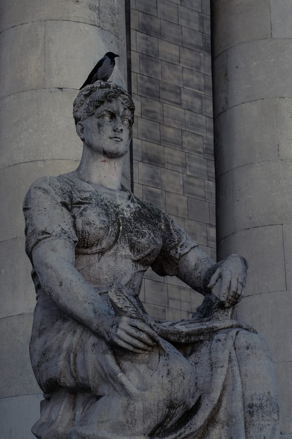 A bird on a statue's head